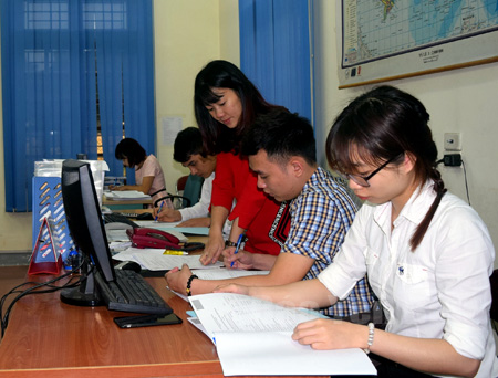 Bà Hoàng Thị Kim Anh (đứng), kiểm tra công tác tổng hợp số liệu điều tra các đơn vị thuộc khối doanh nghiệp trên địa bàn.